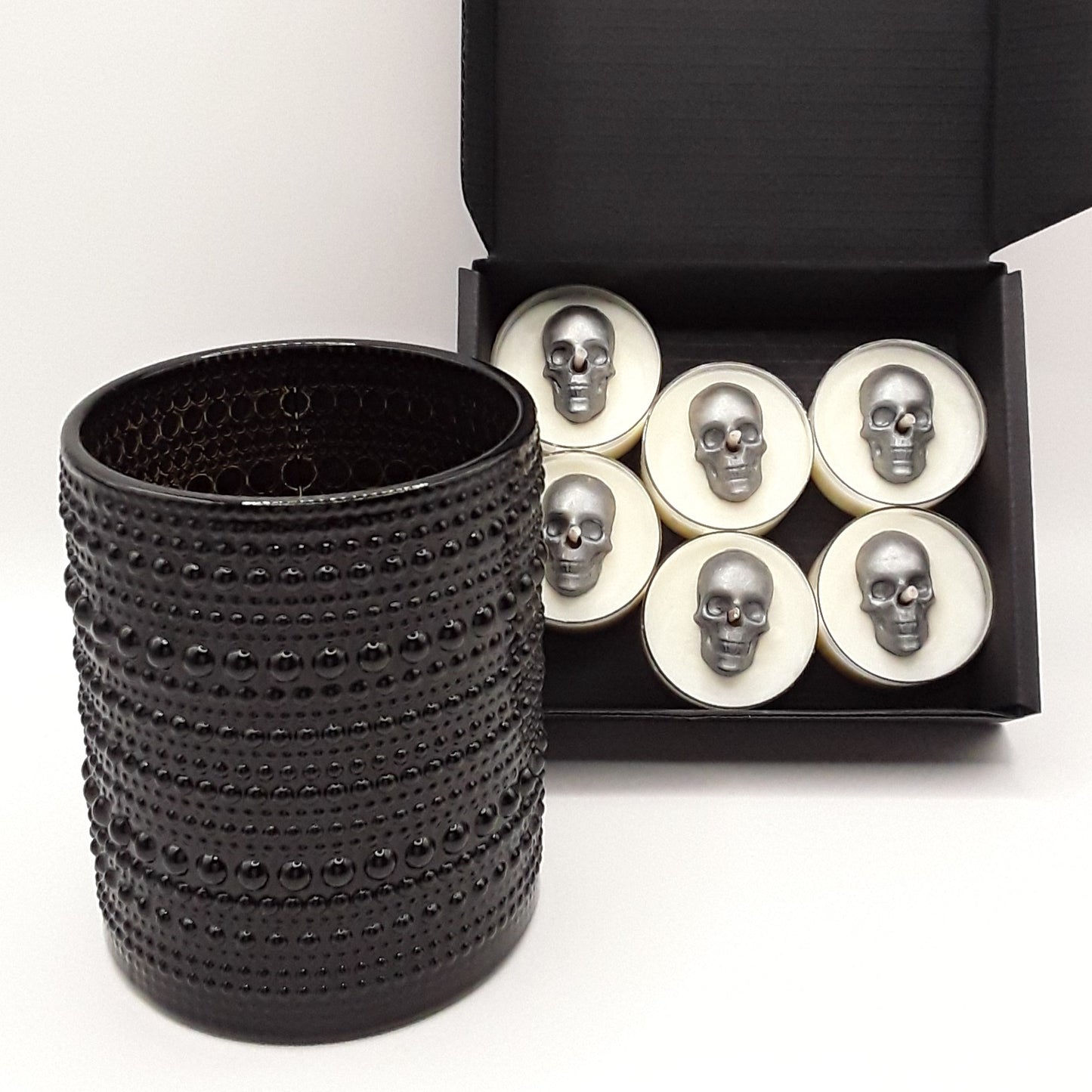 schwarzer Teelichthalter mit sechs Schädel-Teelichtern