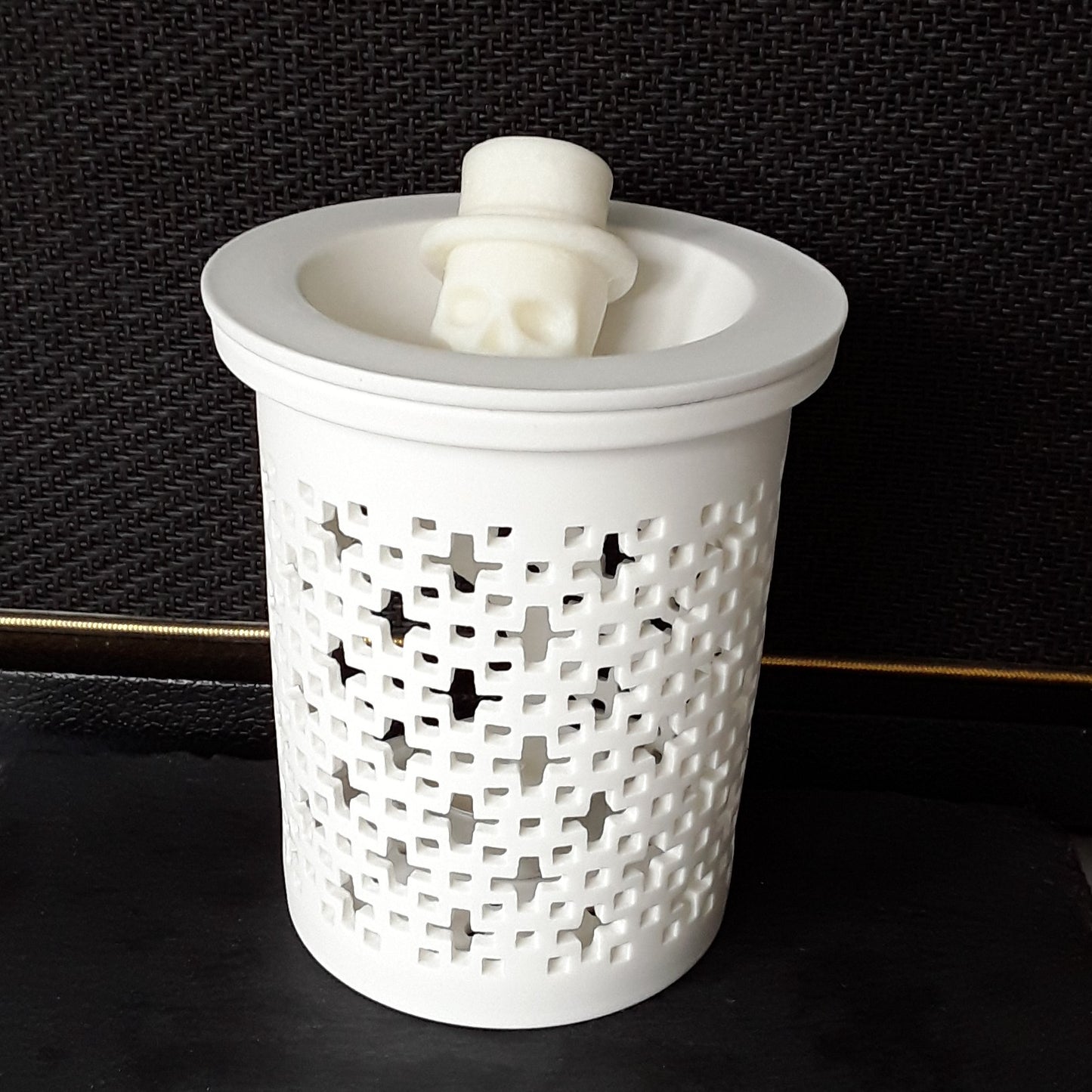 Duftlampe Keramik weiß mit Duftwachs Schädel vor schwarzem Hintergrund