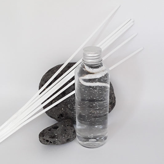 Transparente Flasche mit Diffuserflüssigkeit und sechs weiße Faserstäbchen