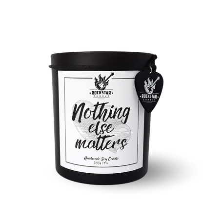 Schwarzes Kerzenglas mit Aufschrift Nothing else matters und Gitarrenplektrum mit Rockstar Candle Logo als Dekoration.
